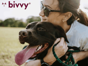 Bivvy pet insurance review featuring a woman hugging a black dog