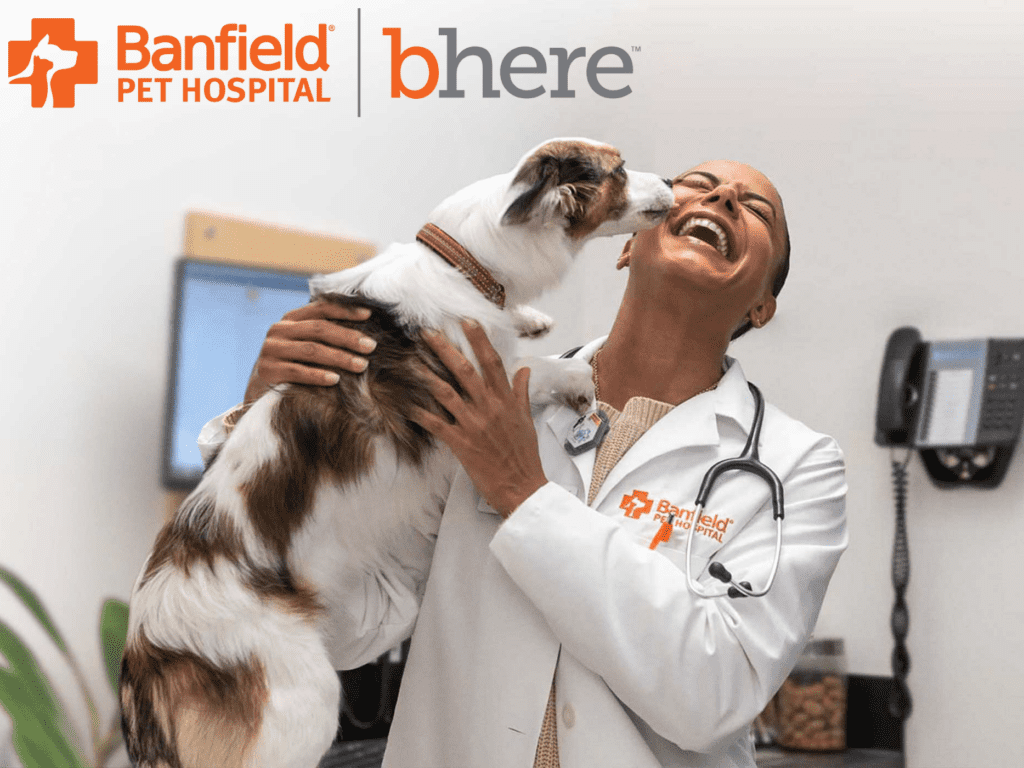 Banfield Pet Hospital featuring a dog licking a veterinarian on the face